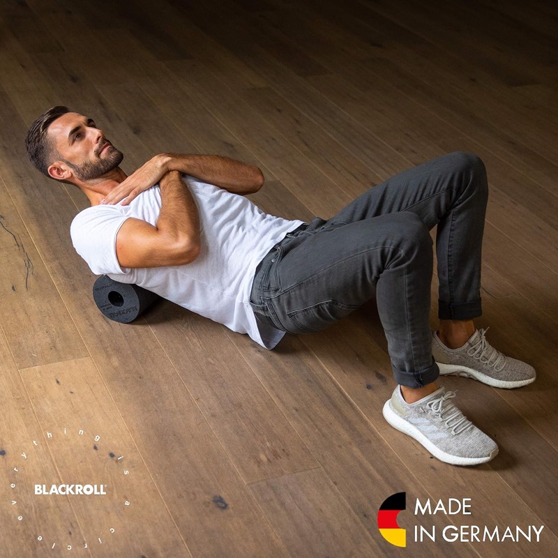 Mann rollt mit der Blackroll den Rücken aus